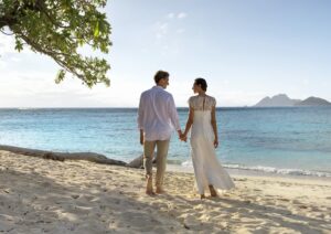 Couple holding hands walking on beach, Fiji Islands